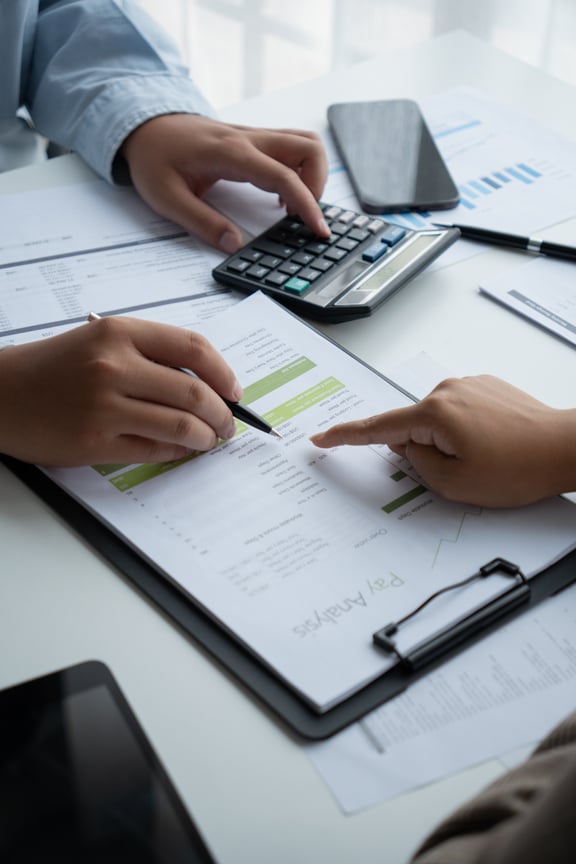 Unterlagen auf Schreibtisch mit den Händen von zwei Personen